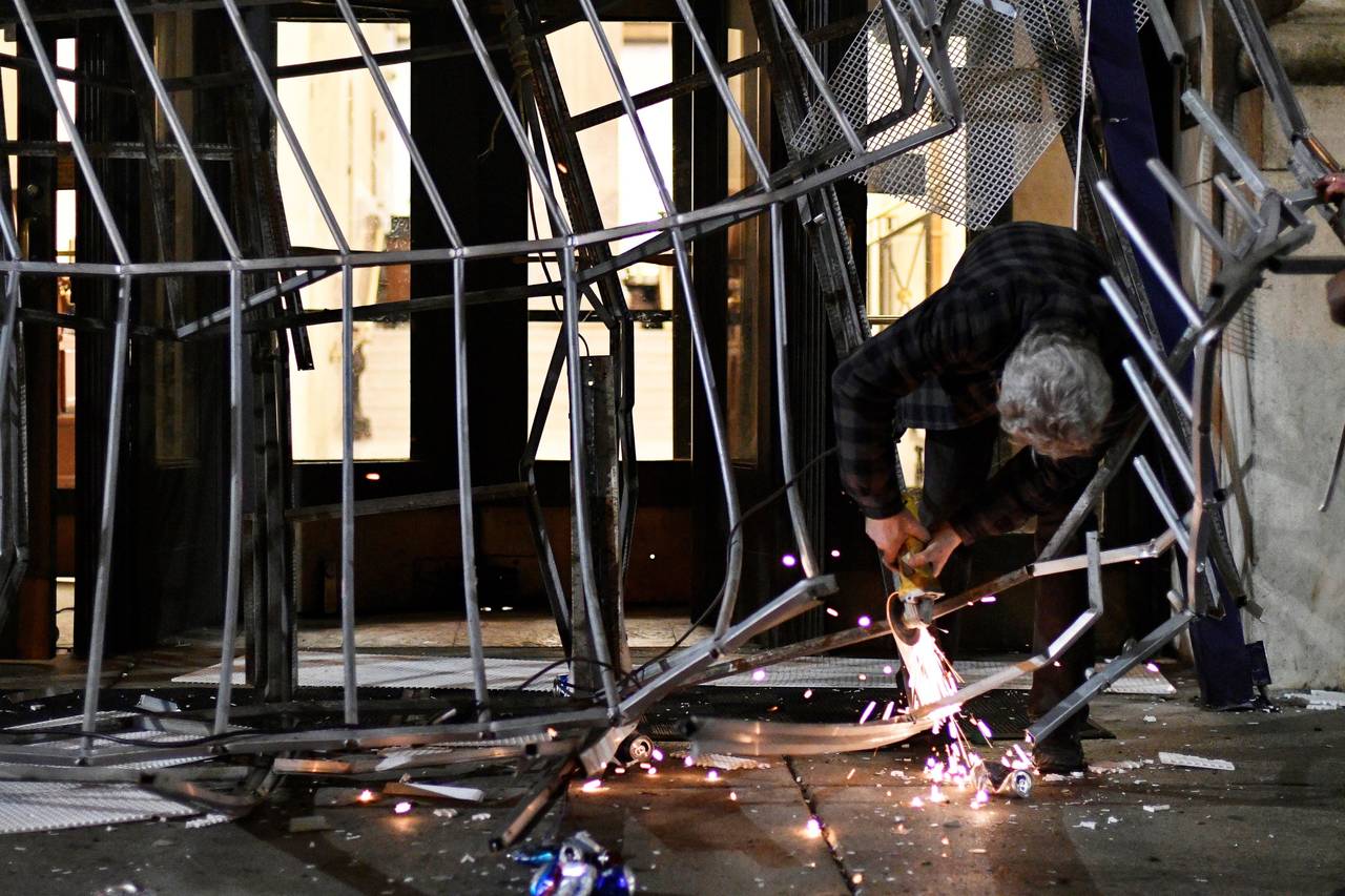 Un hombre intenta reparar el toldo de un hotel roto durante las celebraciones en Filadelfia. Alcalde de Filadelfia pide festejos con orden