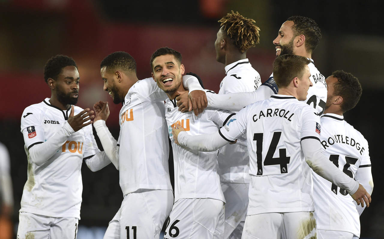 Jugadores del Swansea City en pleno festejo sobre el Huddersfield. (AP)