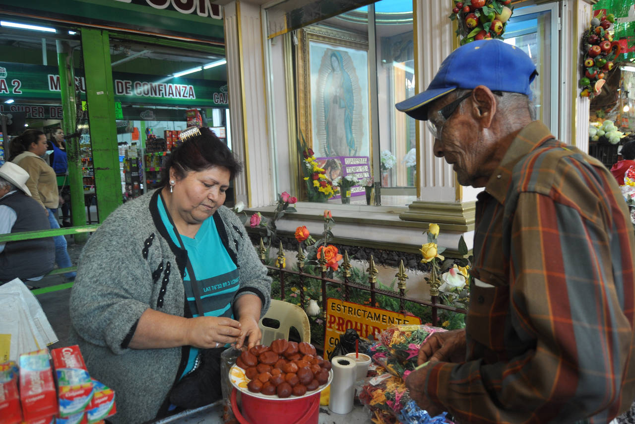 Cuaresma. Doña Laura ofrece sus bolitas de pipián dentro del mercado Alianza; en la imagen aparece don Antonio.