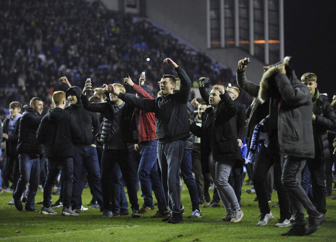 Aficionados del Wigan en el campo, celebrando el logro histórico. (AP)