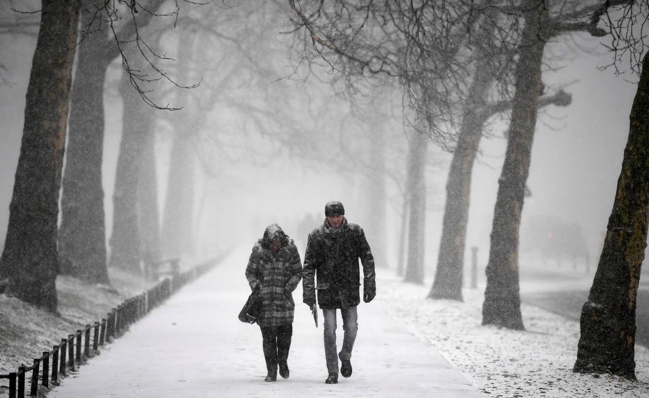 Camino. Una pareja transita por un camino cubierto por la nieve en el Parque Green en Londres. (AP/EFE)