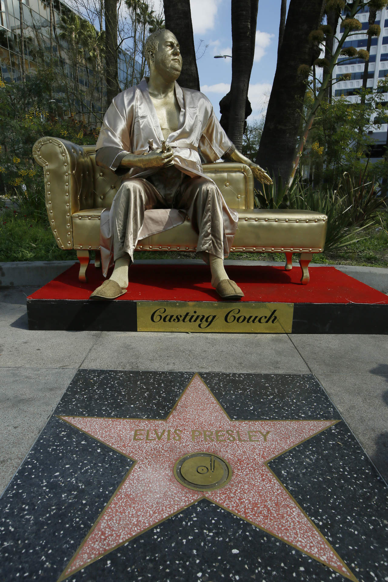 Una estatua dorada de Harvey Weinstein vestido con una bata, sentado imponentemente en un sofá con un Oscar. (ARCHIVO)