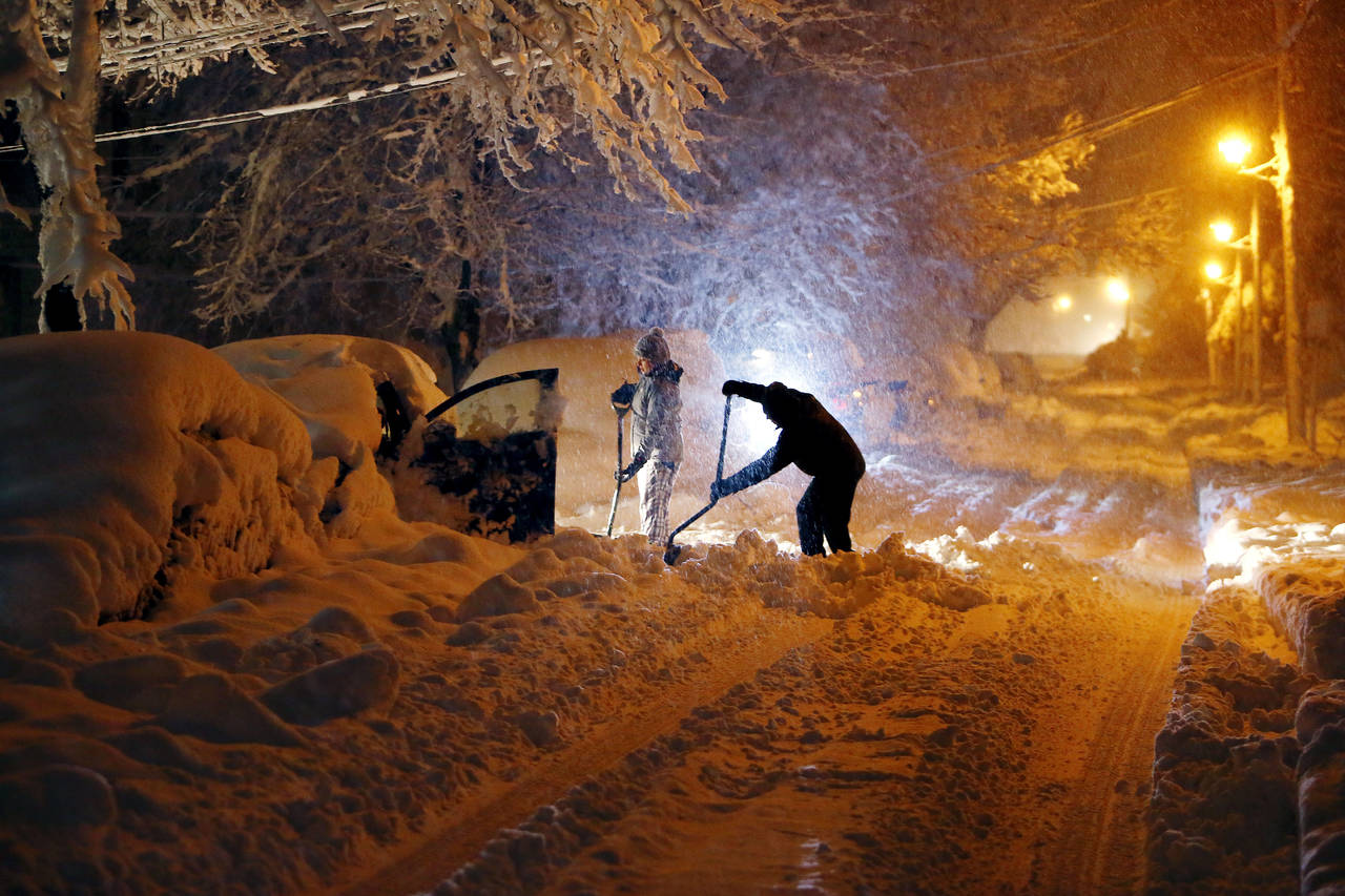 Complicado. Residentes sobre  Mills Street, tratan de limpiar su automóvil que se encuentra debajo de varios centímetros de nieve que cayeron ayer en Morristown, Nueva Jersey. (AP)