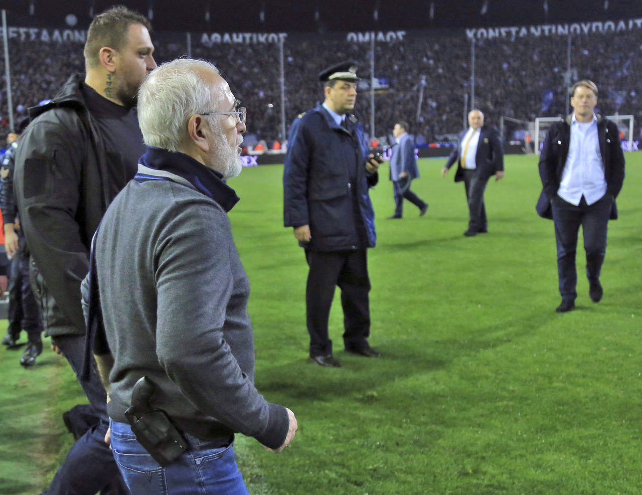 Ivan Savvidis, dueño del PAOK entra armado al terreno de juego luego de que fue anulado un gol a su equipo. (AP)