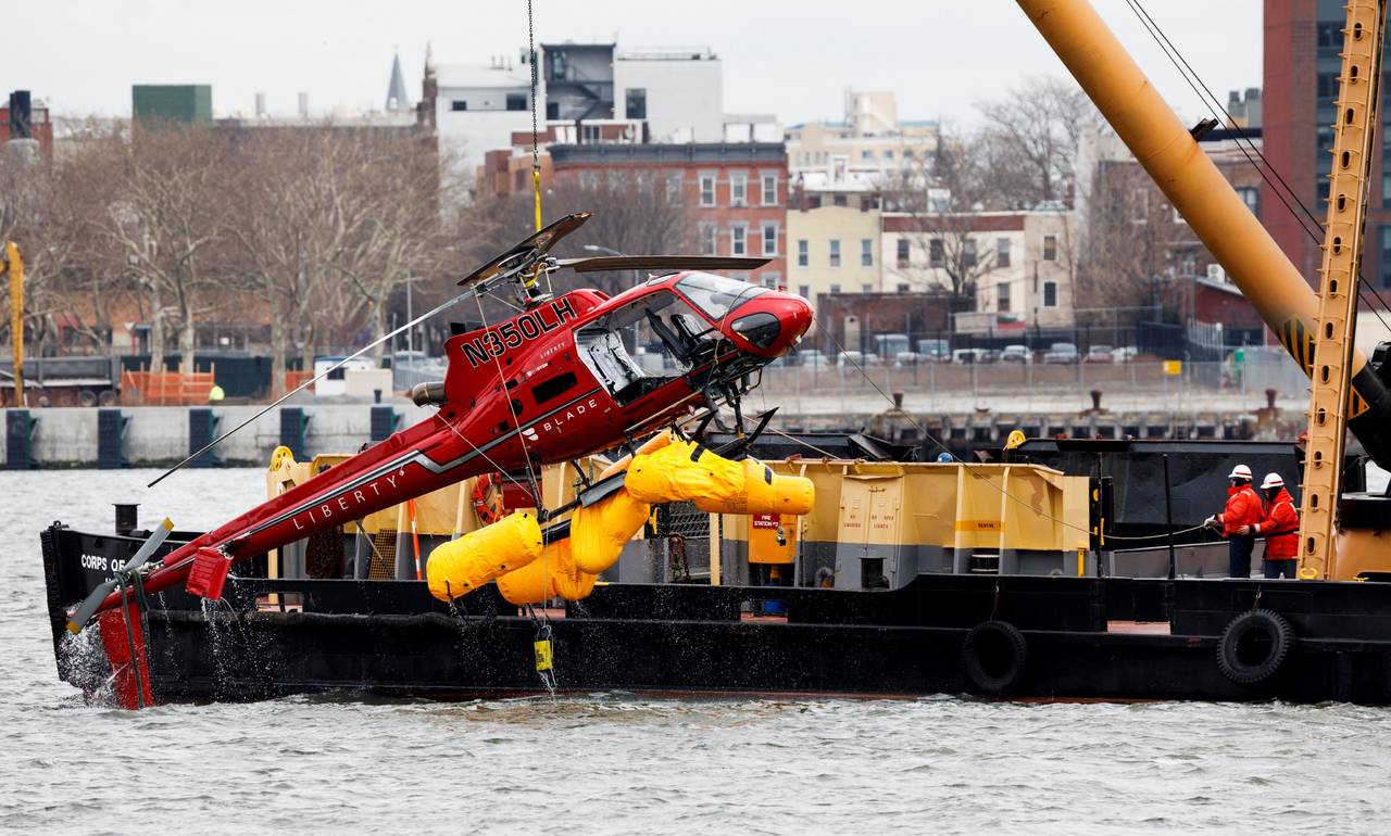 Incidente. Una grúa sacó al helicóptero que cayó en el estrecho del East River de NY. (EFE)
