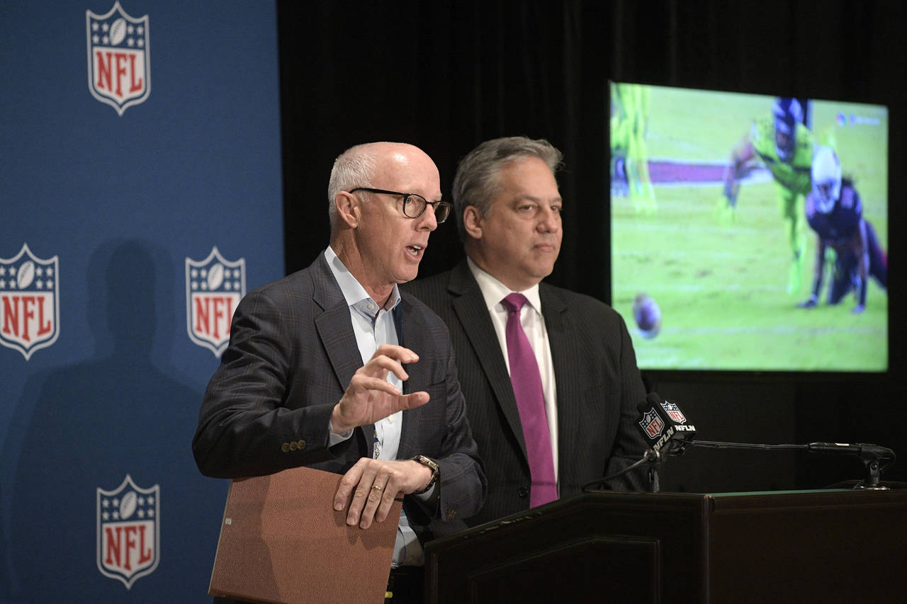 Rich McCay (i), presidente del comité de competencia de la NFL, responde a un reportero junto a Al Riveron, vicepresidente de arbitraje. (AP)