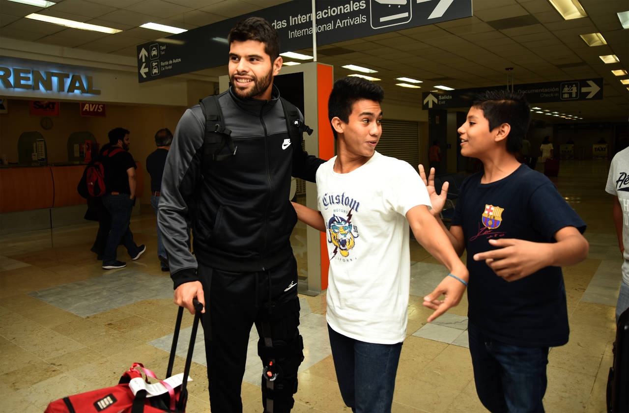 A su llegada anoche al aeropuerto internacional de Torreón, Néstor Araujo se dio el tiempo para saludar a jóvenes aficionados. (JESÚS GALINDO) 