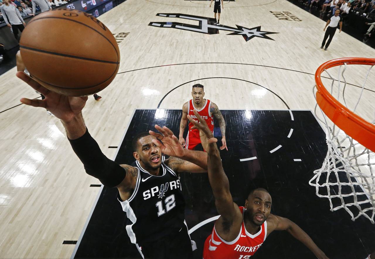 LaMarcus Aldridge, de los Spurs de San Antonio, intenta anotar frente a  Luc Mhah, de los Rockets de Houston. (EFE)