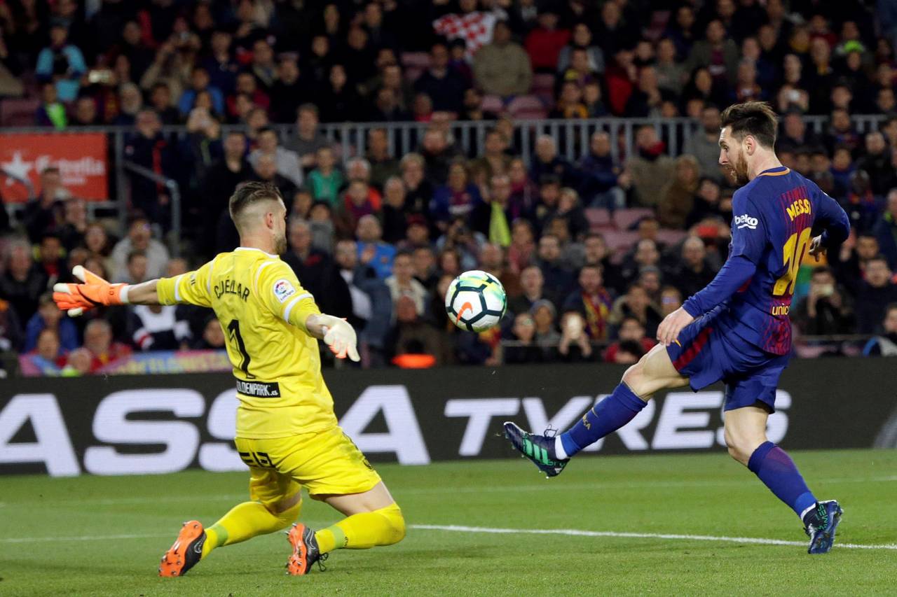 El delantero del FC Barcelona Leo Messi (d) marca el tercer gol ante el Leganés, durante el partido de Liga en Primera División disputado anoche. (EFE)