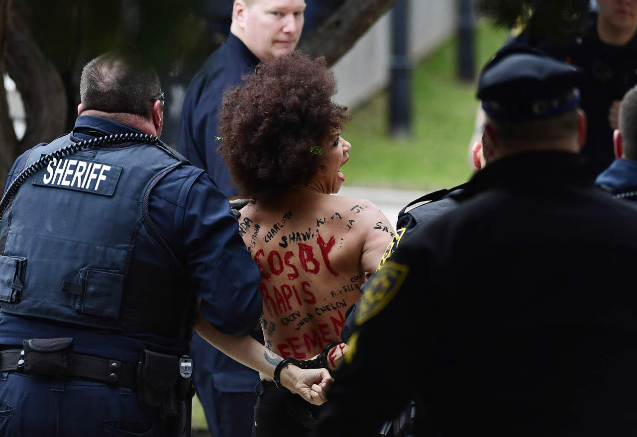 Manifestante en topless grita 'La vida de las mujeres importa' mientras Cosby se dirigía a su segundo juicio.  (ARCHIVO)