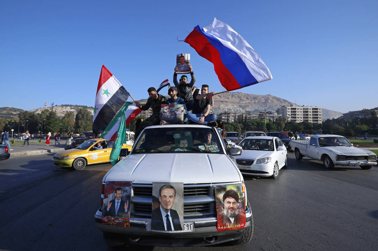 Respuesta. Varias personas se manifestaron esta mañana en Damasco en favor de Al Assad y de Rusia. (AP)