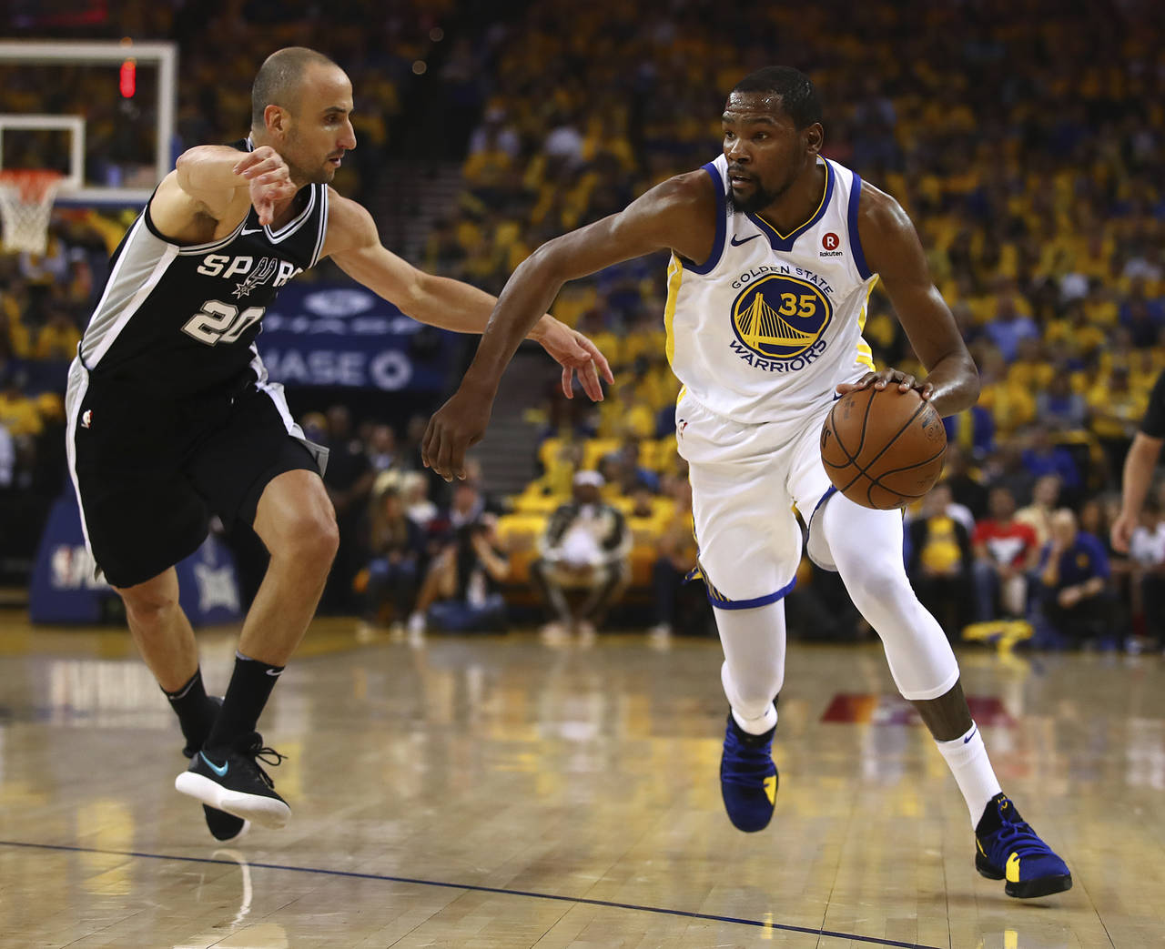Kevin Durant, de los Warriors de Golden State, lleva al balón frente a Manu Ginóbili, de los Spurs de San Antonio. (AP)