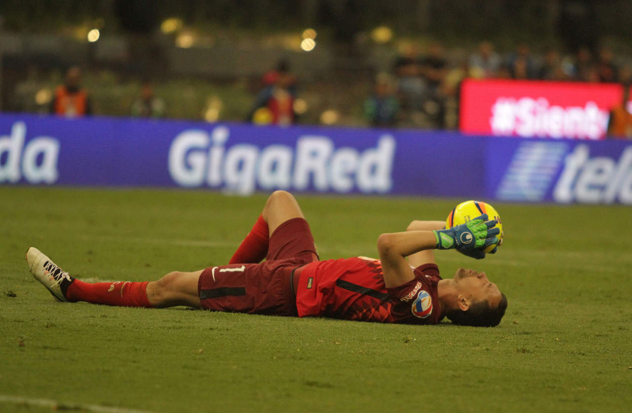 El portero Agustín Marchesín yace en el césped del Estadio Azteca con el control del balón. (Notimex)
