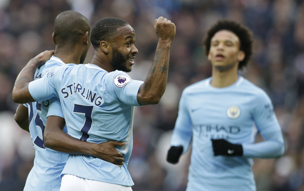 Raheem Sterling celebra con su compañero Fernandinho. Manchester City pasa los 100 goles