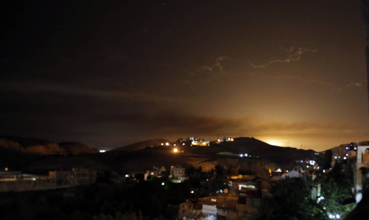 Reacción. Detrás de una colina en Siria se observa el resplandor de un misil que lanzó la aviación israelí bombardeó  en la madrugada de este jueves sobre objetivos iraníes. (AP)