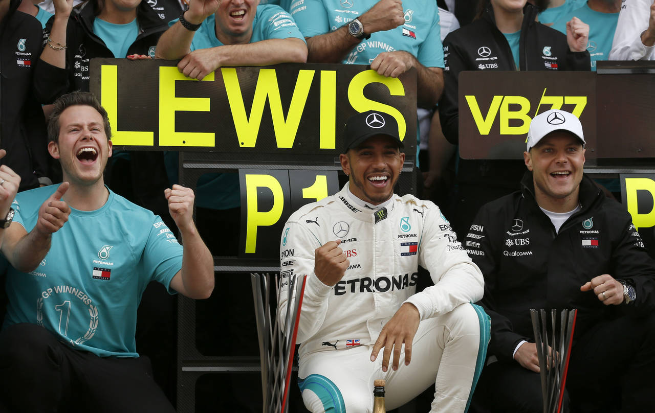 Lewis Hamilton (i) amplió su ventaja en la clasificación de pilotos sobre Sebastian Vettel tras una fácil victoria en el Gran Premio de España. (AP)