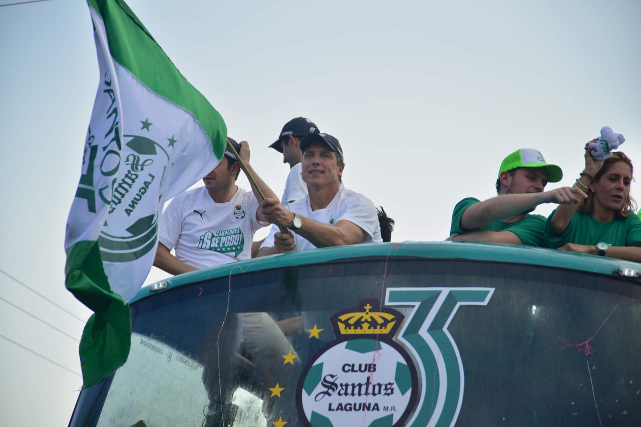 Robert Dante Siboldi ondea una bandera albiverde durante el desfile del campeonato. (Ernesto Ramírez, Fernando Compeán y Erick Sotomayor)