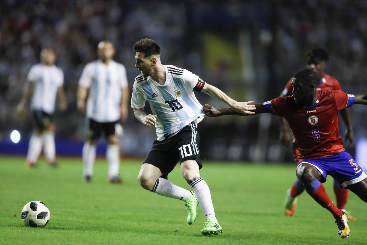 El jugador de Argentina Lionel Messi (i) disputa un balón con Carlens Arcus (d) de Haití, durante un partido amistoso en  'La Bombonera' de Buenos Aires.  (Fotografías de EFE)