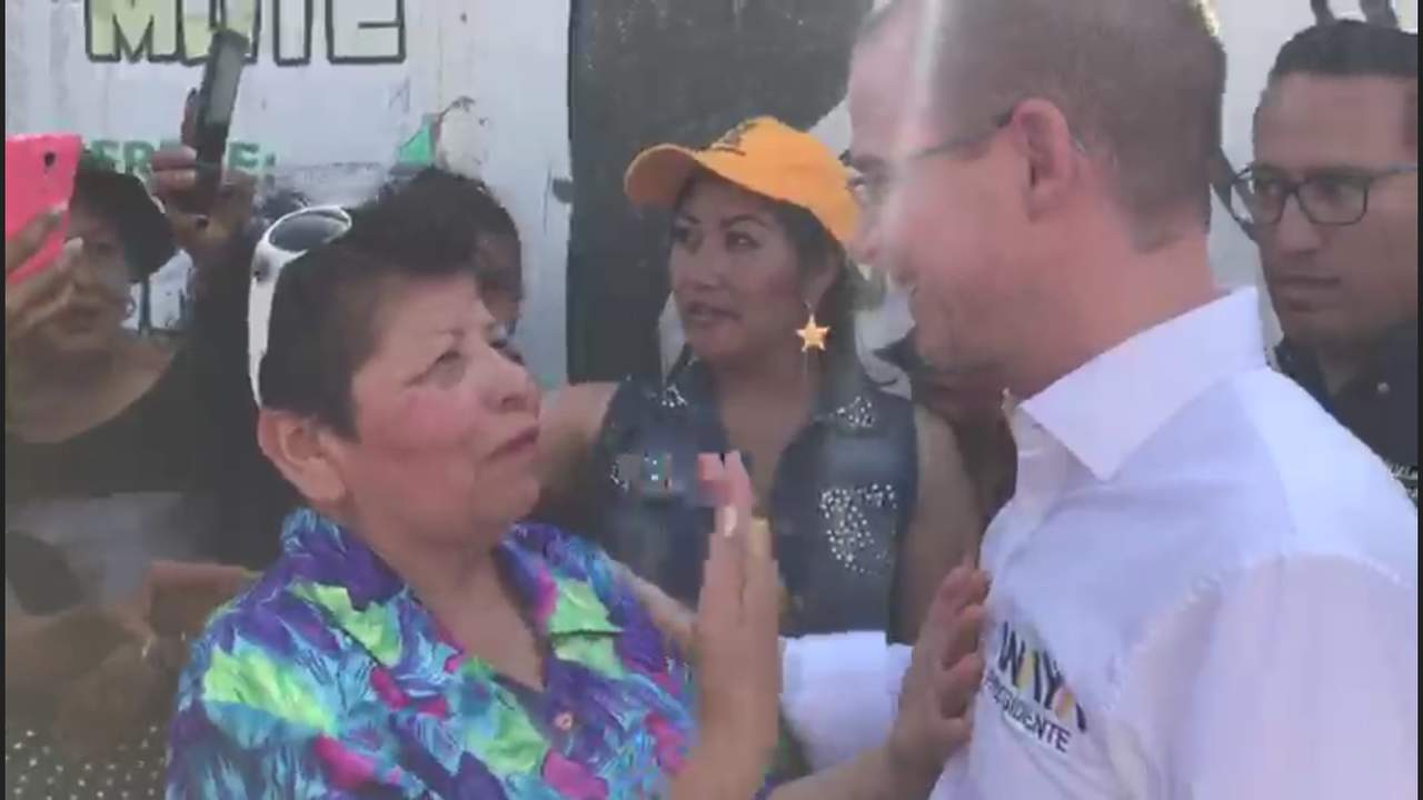 Anaya camina lento y una vez en el centro de la calle, finalmente mira de frente a la mujer, ella le dice 'si quieres que uno te apoye, ya deja de hablar de López Obrador, haz tu campaña sobre ti, lo bueno que traes para nuestro (beneficio), de México'. (ESPECIAL)