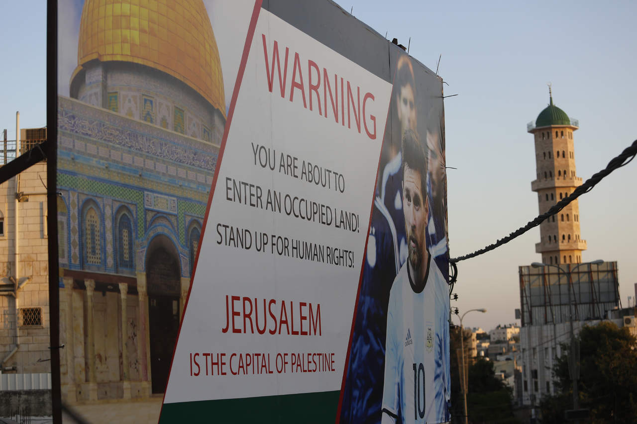 Un cartel que protesta por el partido amistoso entre Israel y Argentina se ve en una calle principal en la ciudad cisjordana de Hebrón mostrando a la superestrella argentina Lionel Messi. (AP)