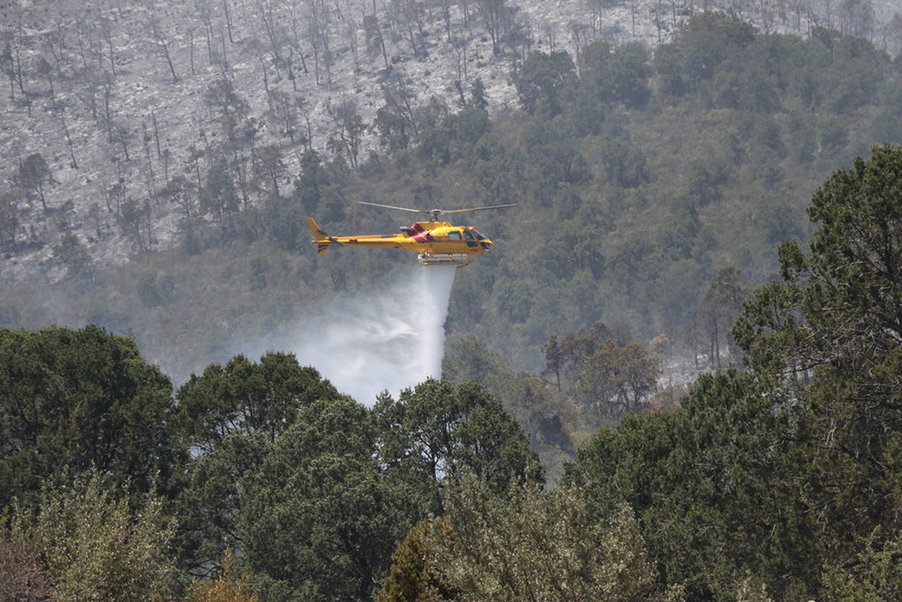 Labores. Helicópteros continúan en la zona afectada para evitar que el fuego se reavice.