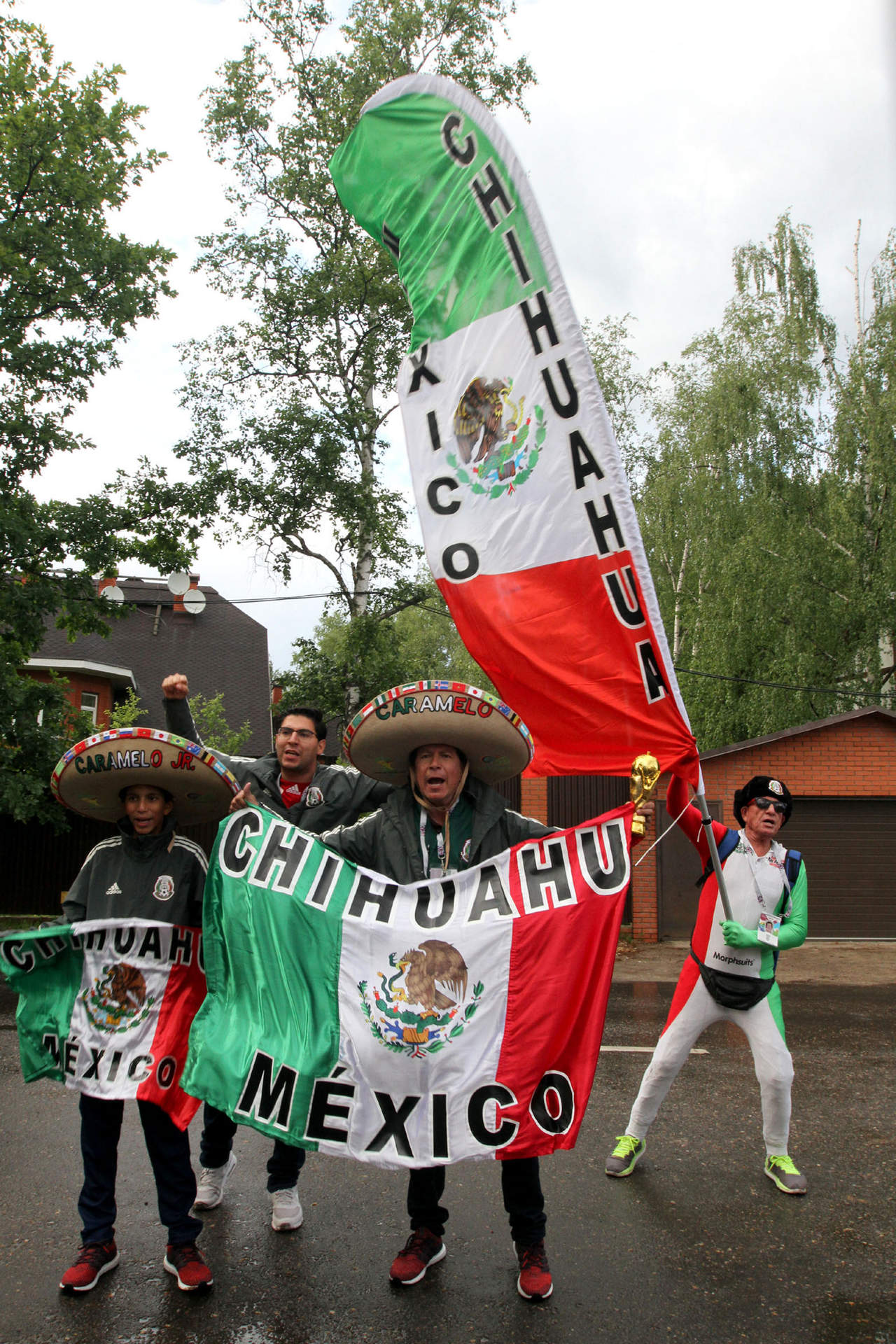 Varios aficionados sostienen banderas de México afuera de las instalaciones del club Dinamo de Moscú. (Notimex)