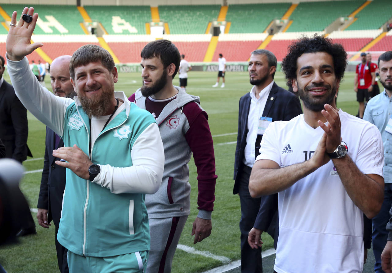 El delantero egipcio Mohammed Salah (derecha) y el líder de Chechenia Ramzan Kadyrov saludan a hinchas durante un entrenamiento. (AP)