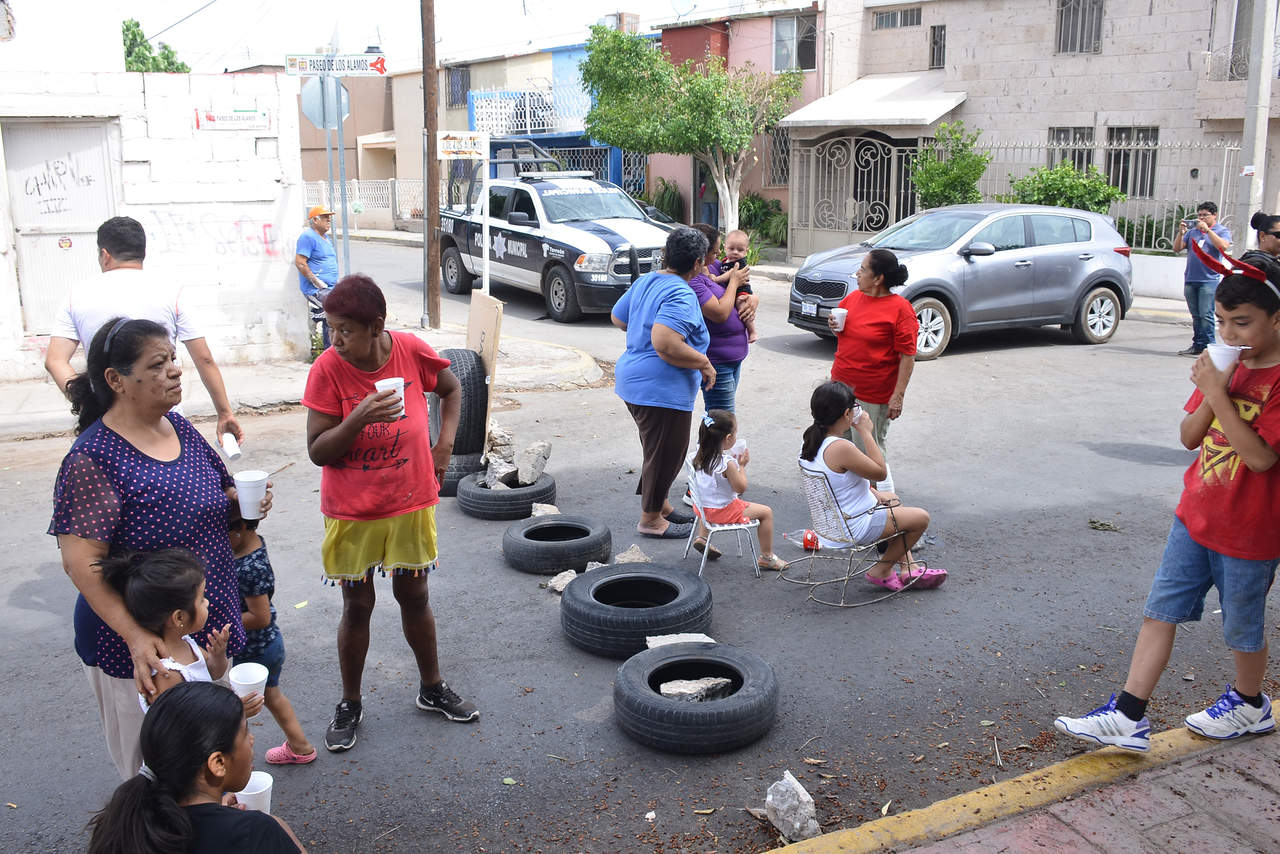Vecinos de la colonia Jacarandas bloquearon la mañana de este martes con cajas de plástico y llantas el Paseo de los Álamos, a la altura de la calle Granados. (FERNANDO COMPEÁN)
