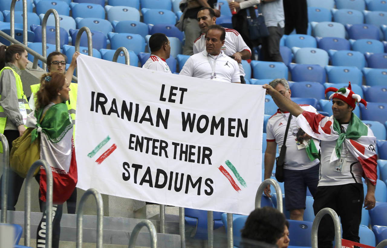 Un grupo de hinchas muestra un cartel en el que se exige que se permita a las mujeres ingresar en los estadios. (AP)
