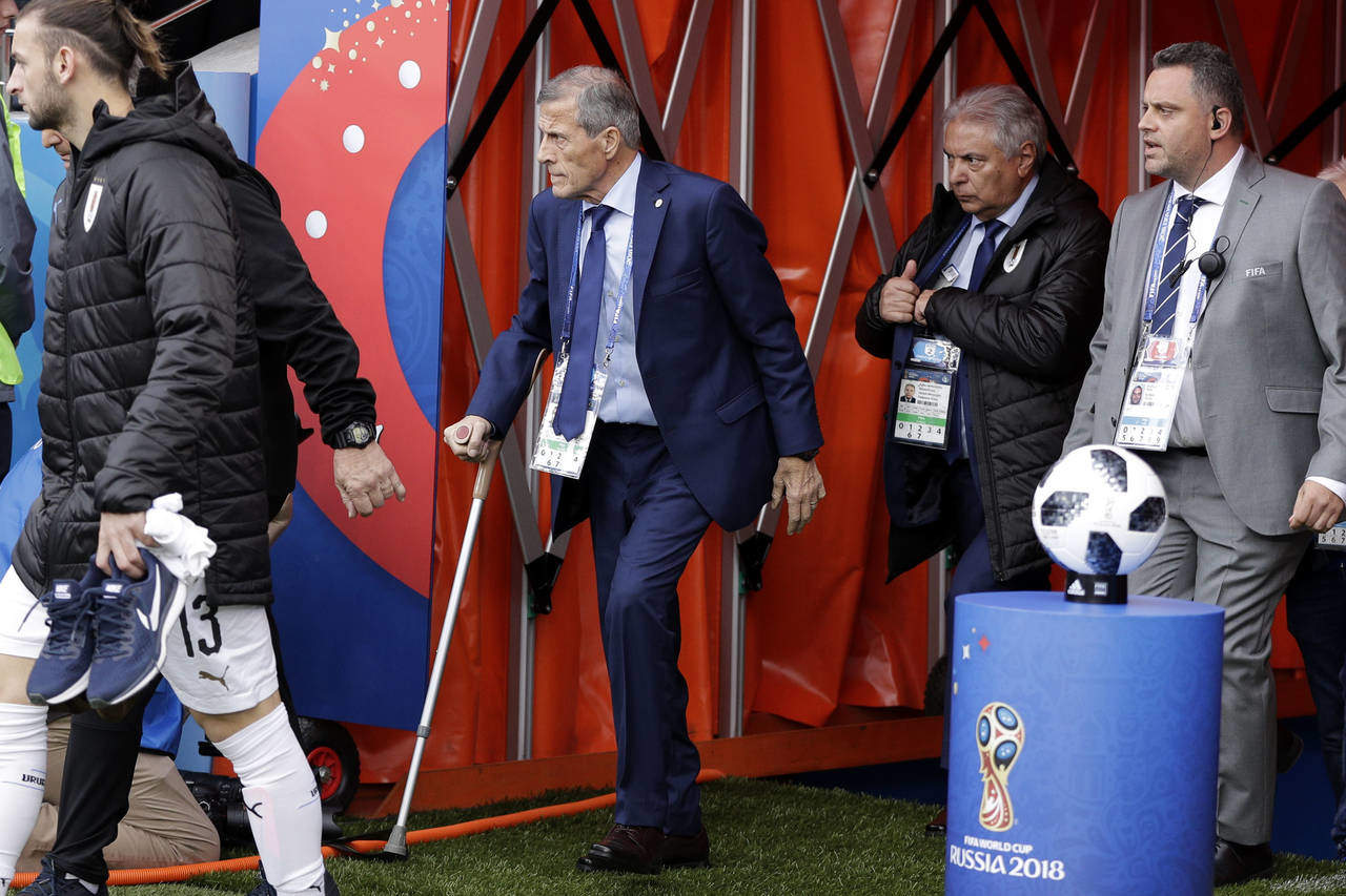 El técnico de Uruguay Óscar Tabárez (centro) se dirige al banquillo para el partido contra Egipto por el Grupo A. (AP)