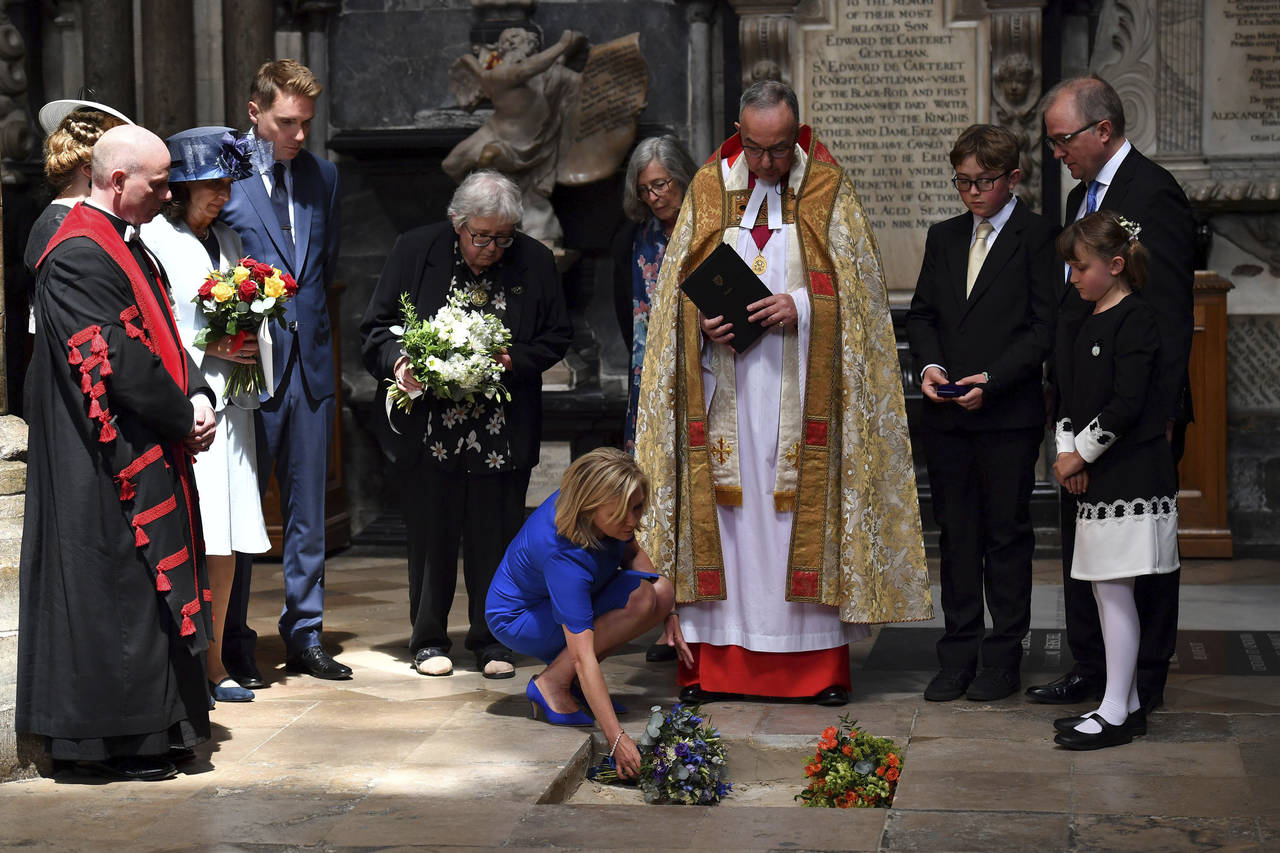 Homenaje. Lucy Hawking pone flores mientras las cenizas de su padre, Stephen Hawking, son sepultadas en la Abadía de Westminster en Londres, entre los científicos Charles Darwin e Isaac Newton. (ARCHIVO)