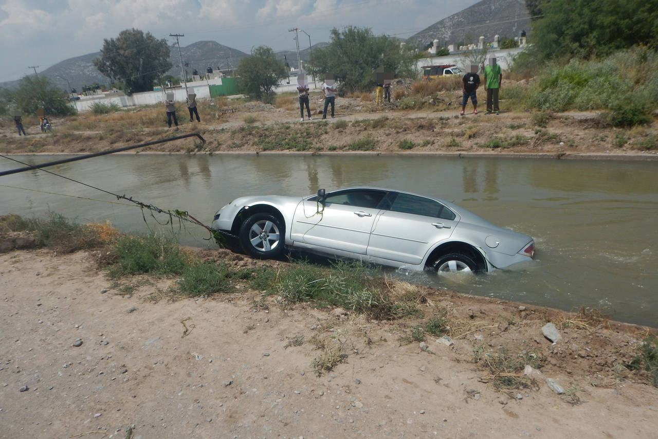 Rescate. El vehículo fue sacado del agua por personal de Protección Civil y los Buzos Castañeda. (EL SIGLO DE TORREÓN) 