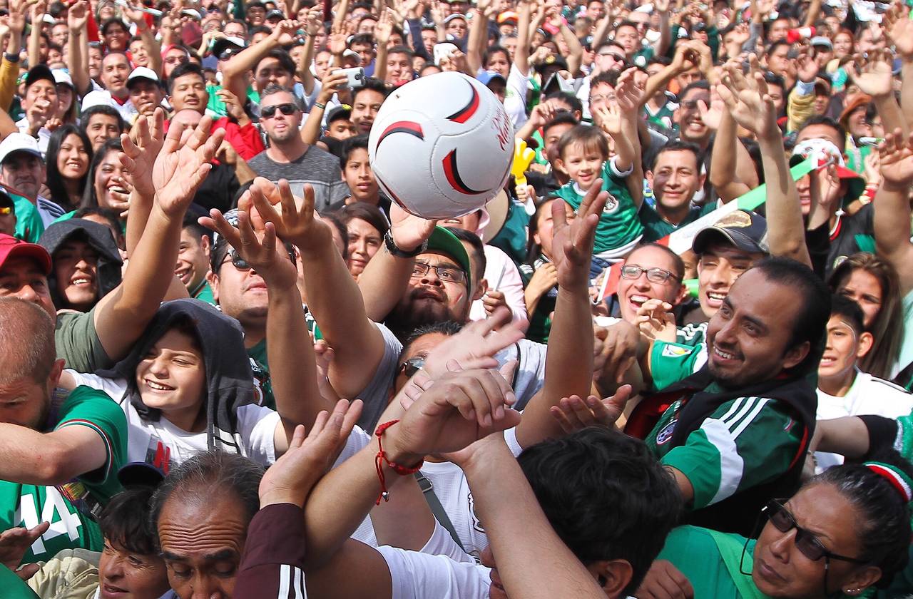 Aficionados que se dieron cita en el Zócalo capitalino celebran el gol de la Selección de México. (Notimex)