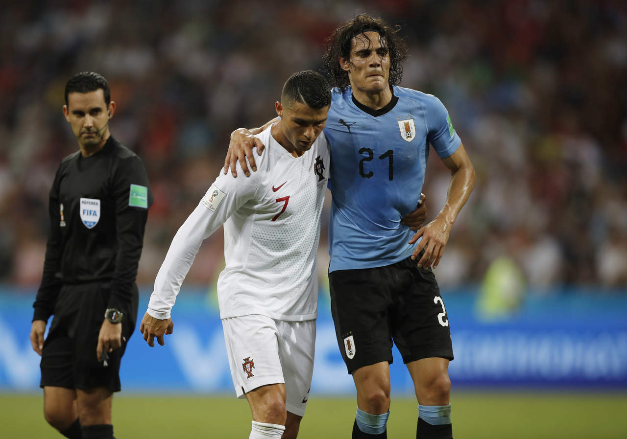 Cristiano Ronaldo ayuda a Edinson Cavani a salir de la cancha luego de que el uruguayo se lesionara en el juego. (AP)