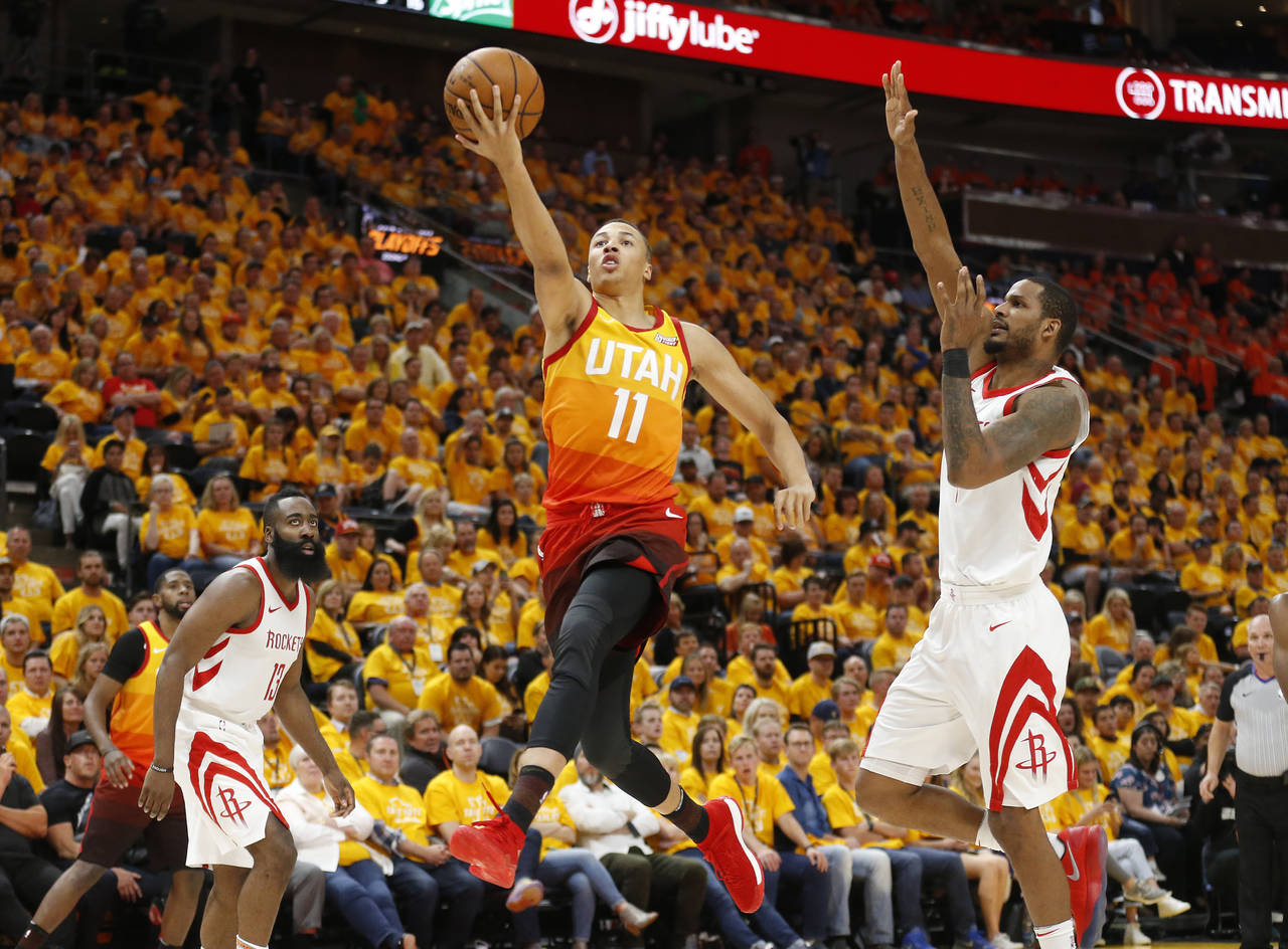 El base Dante Exum (11), del Jazz de Utah, salta hacia la canasta mientras el alero Trevor Ariza, de los Rockets de Houston intenta bloquearlo durante un partido de postemporada en Salt Lake City. (AP) 