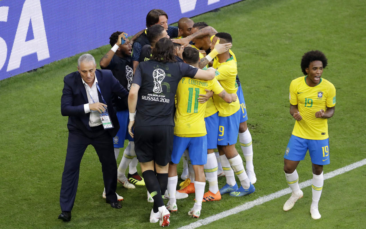 El delantero de Brasil Roberto Firmino, rodeado por sus compañeros, celebra con el técnico Tite tras anotar el segundo gol en los octavos de final del Mundial en Samara. (AP)