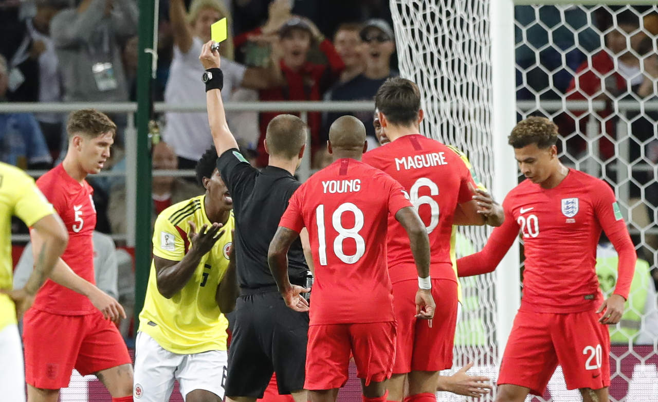 El árbitro Mark Geiger (c) amonesta al volante colombiano Carlos Sánchez durante el partido contra Inglaterra. (AP)