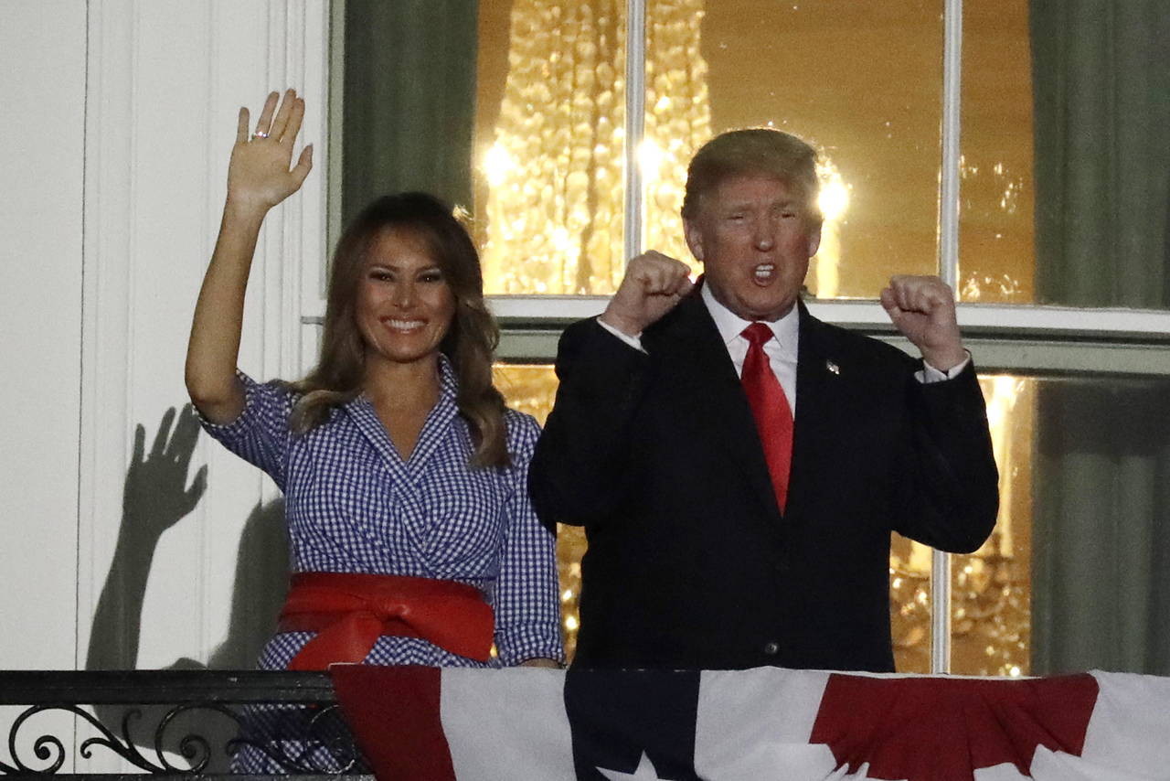 Celebran. Donald Trump saluda junto a Melania Trump, desde un balcón de la Casa Blanca durante los fuegos artificiales. (EFE)
