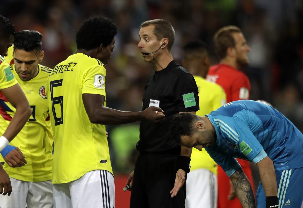 El defensor de Colombia Carlos Sánchez reclama al árbitro Mark Geiger en el partido contra Inglaterra. (AP)