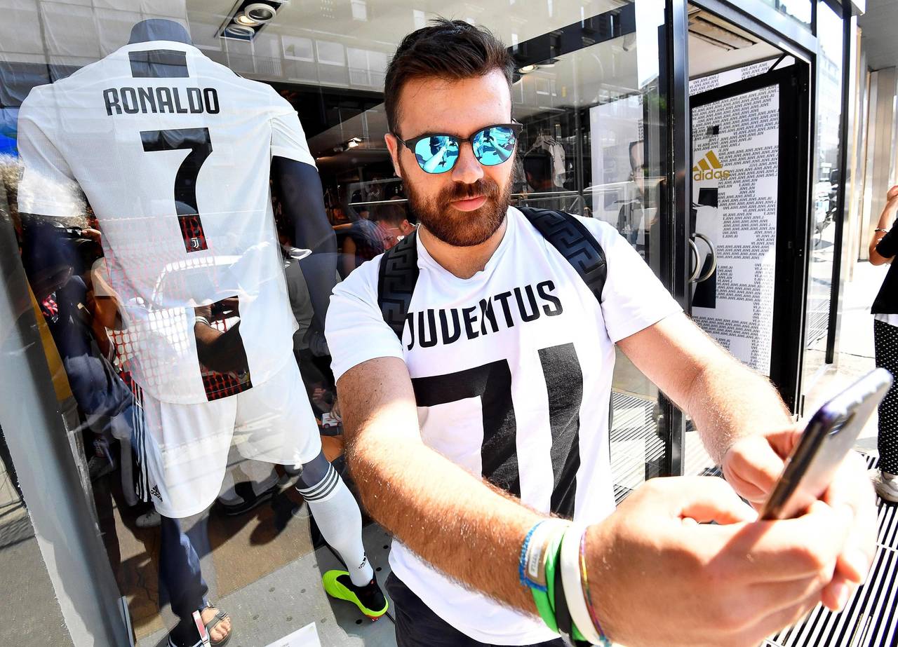 Un aficionado del Juventus posa con la nueva camiseta 'bianconera' que lucirá el delantero portugués Cristiano Ronaldo frente a la tienda oficial del Juventus en Milán. (EFE)