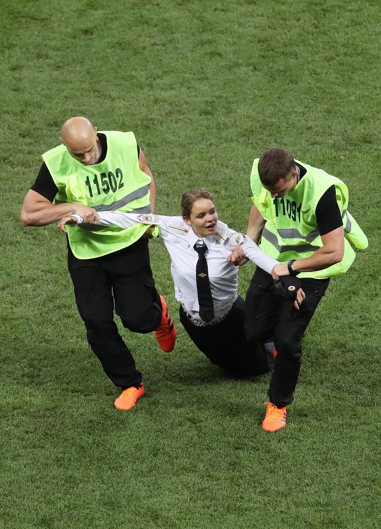 Una mujer es retirada del terreno de juego tras invadir la cancha en la final del Mundial. (AP)