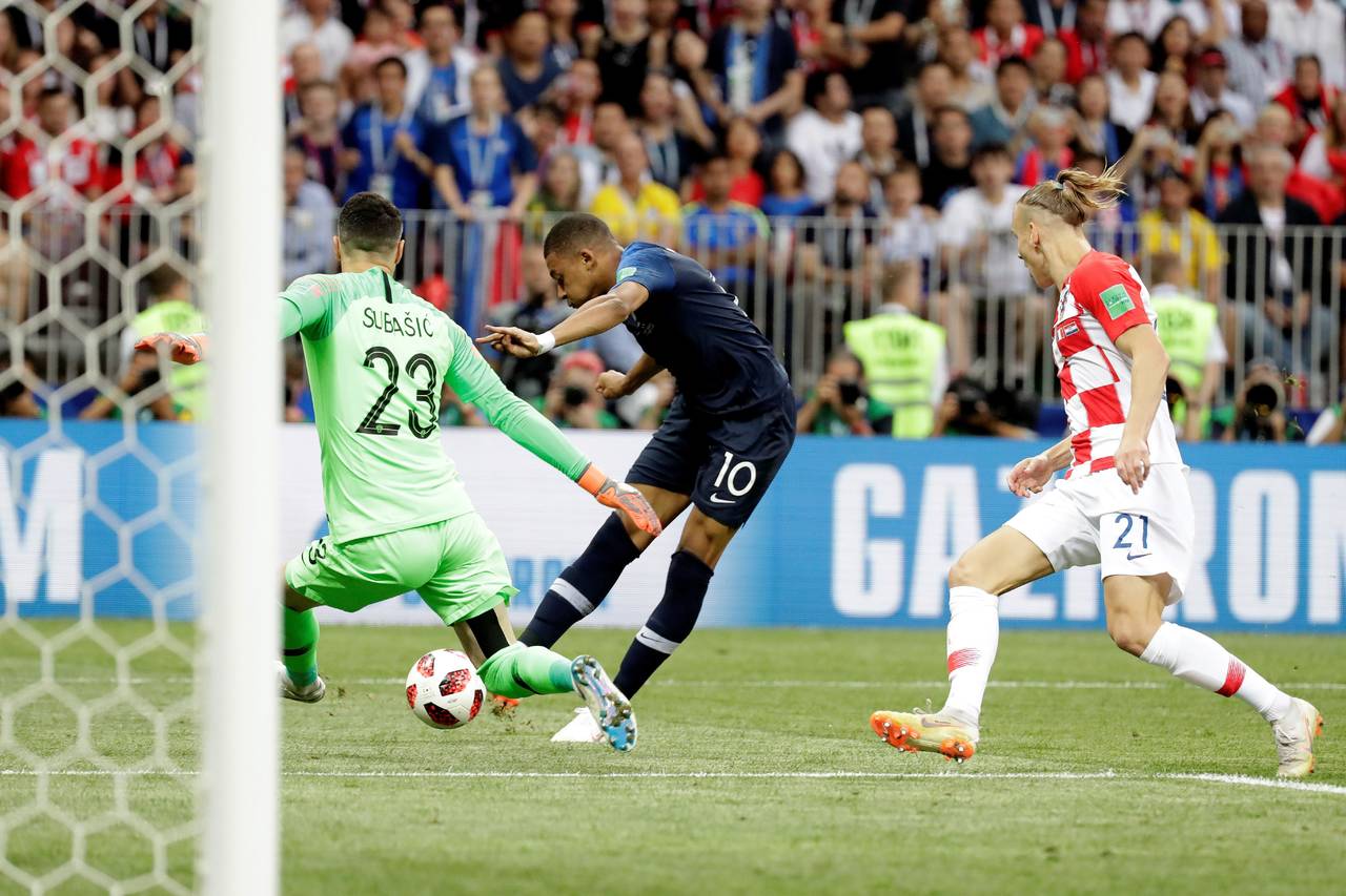 El delantero francés Kylian Mbappé (c) intenta marcar ante el portero croata Danijel Subasic (i) durante el partido Francia-Croacia, final del Mundial. (EFE)