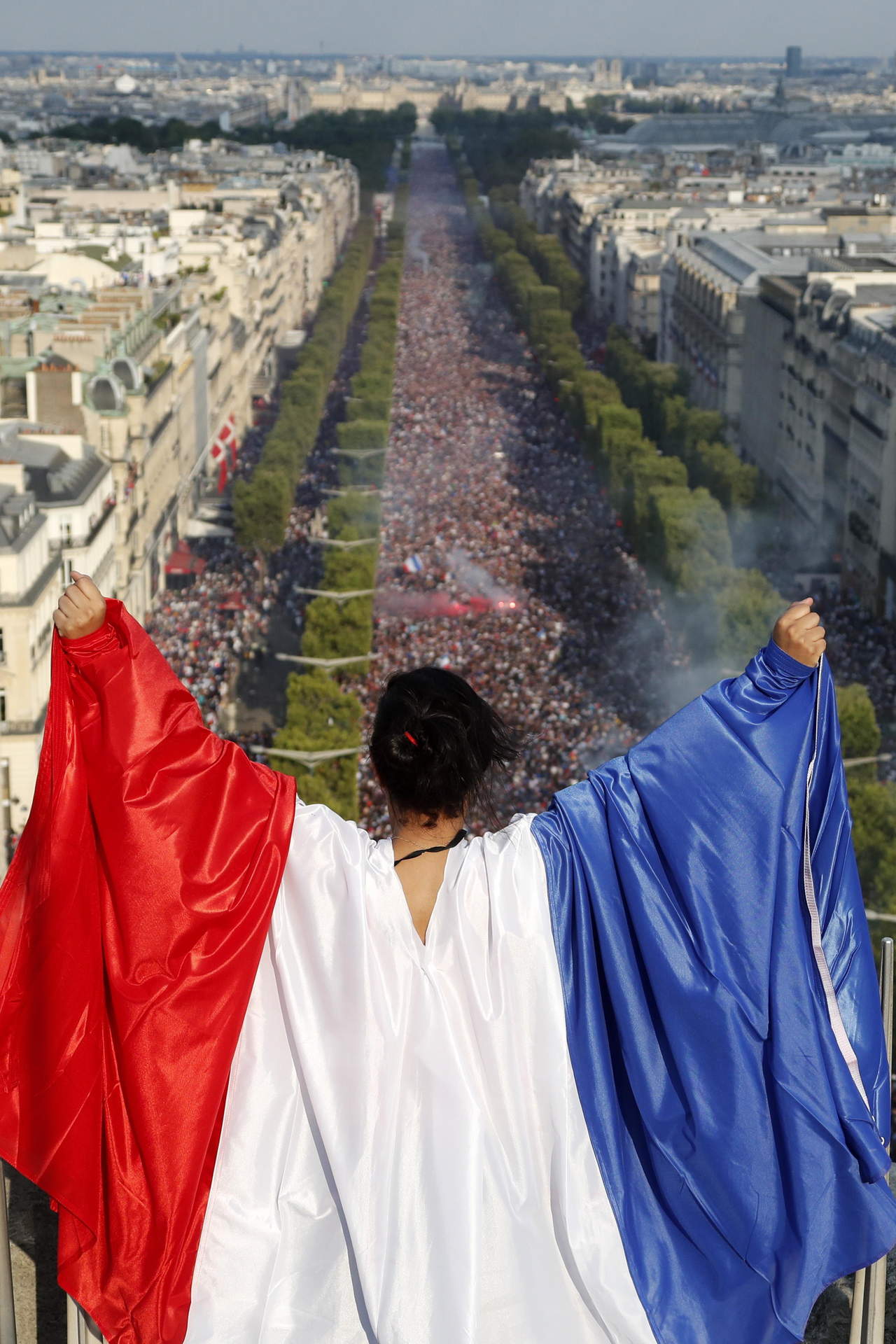 Una aficionada observa el festejo de miles de franceses desde lo alto en París. (EFE)