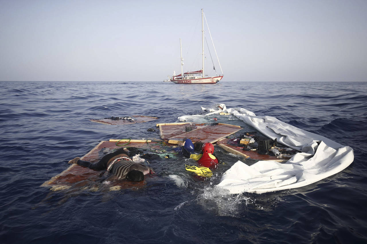 Un rescatista salva a una mujer de nombre Josephine que se aferraba a una tabla en el mar Mediterráneo. (AP)