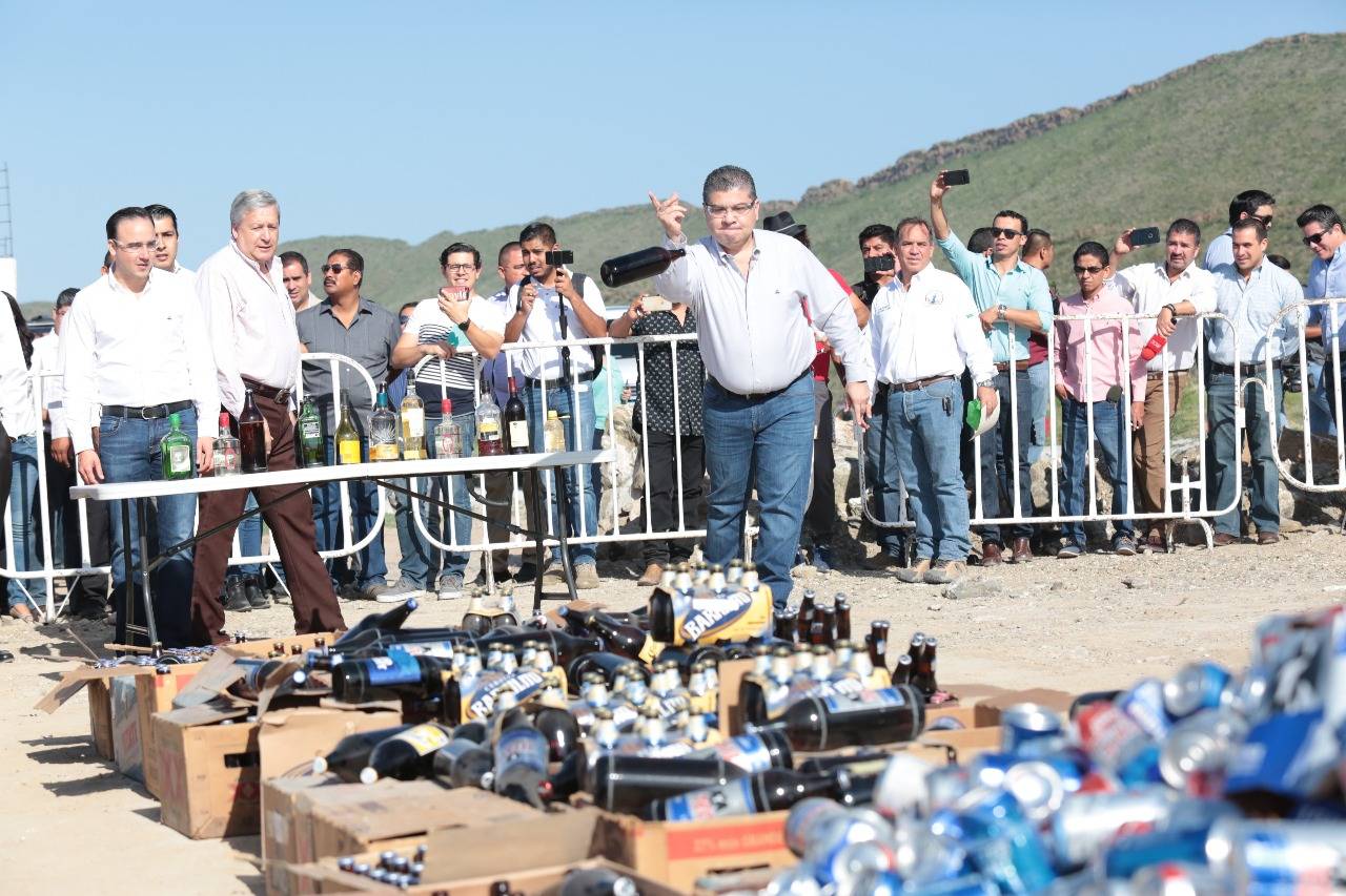 Seguridad. El gobernador Miguel Riquelme avienta un envase de cerveza, durante el evento de destrucción de objetos del delito.