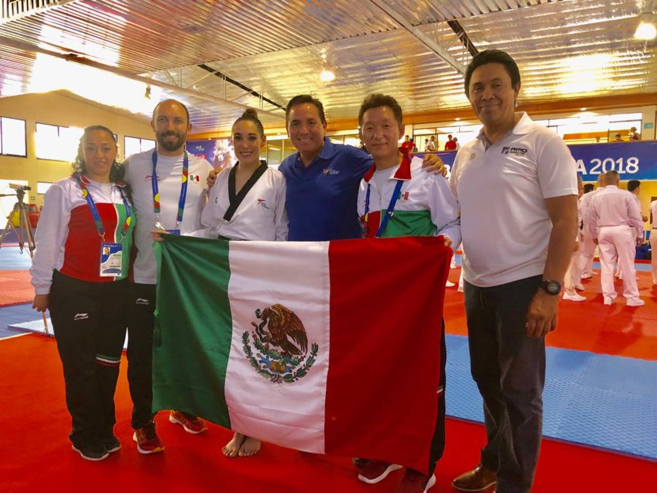 La delegación mexicana de TKD se muestra orgullosa con una bandera tras las participación en el primer día de competencia. Hay felicidad en equipo de taekwondo.
