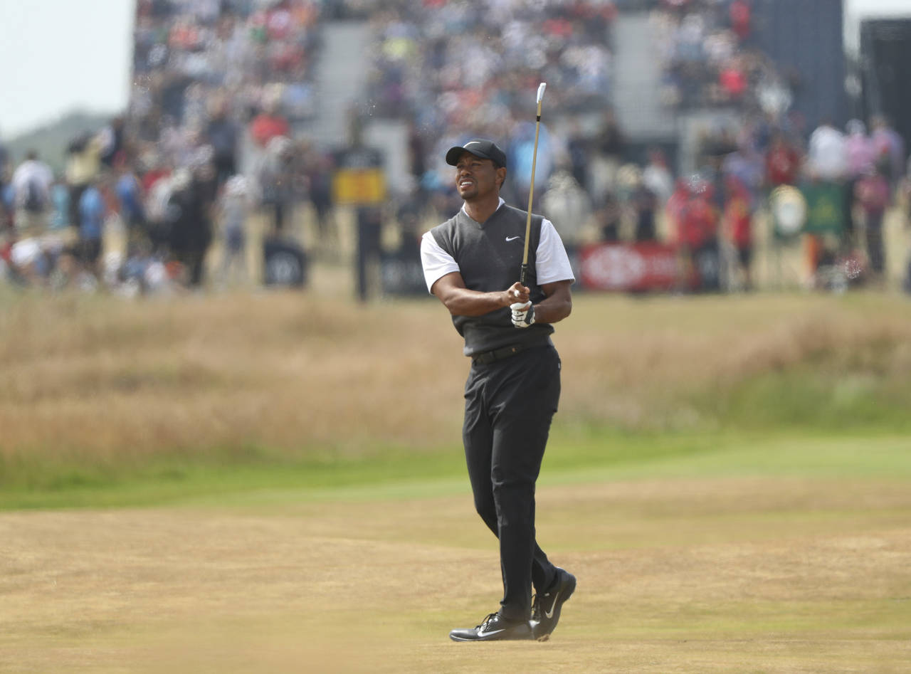 El estadounidense Tiger Woods mira su disparo en el fairway del sexto hoyo ayer, en la tercera ronda del Abierto Británico en Carnoustie, Escocia. (AP)