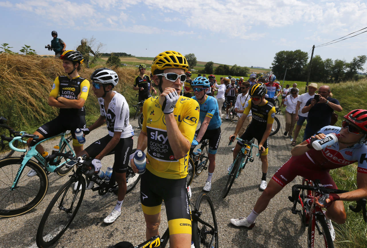 El líder general Geraint Thomas (casaca amarilla) aguarda en medio de una protesta de granjeros durante la 16ta etapa del Tour de Francia, el martes 24 de julio de 2018. Alaphilippe gana la 16ta etapa