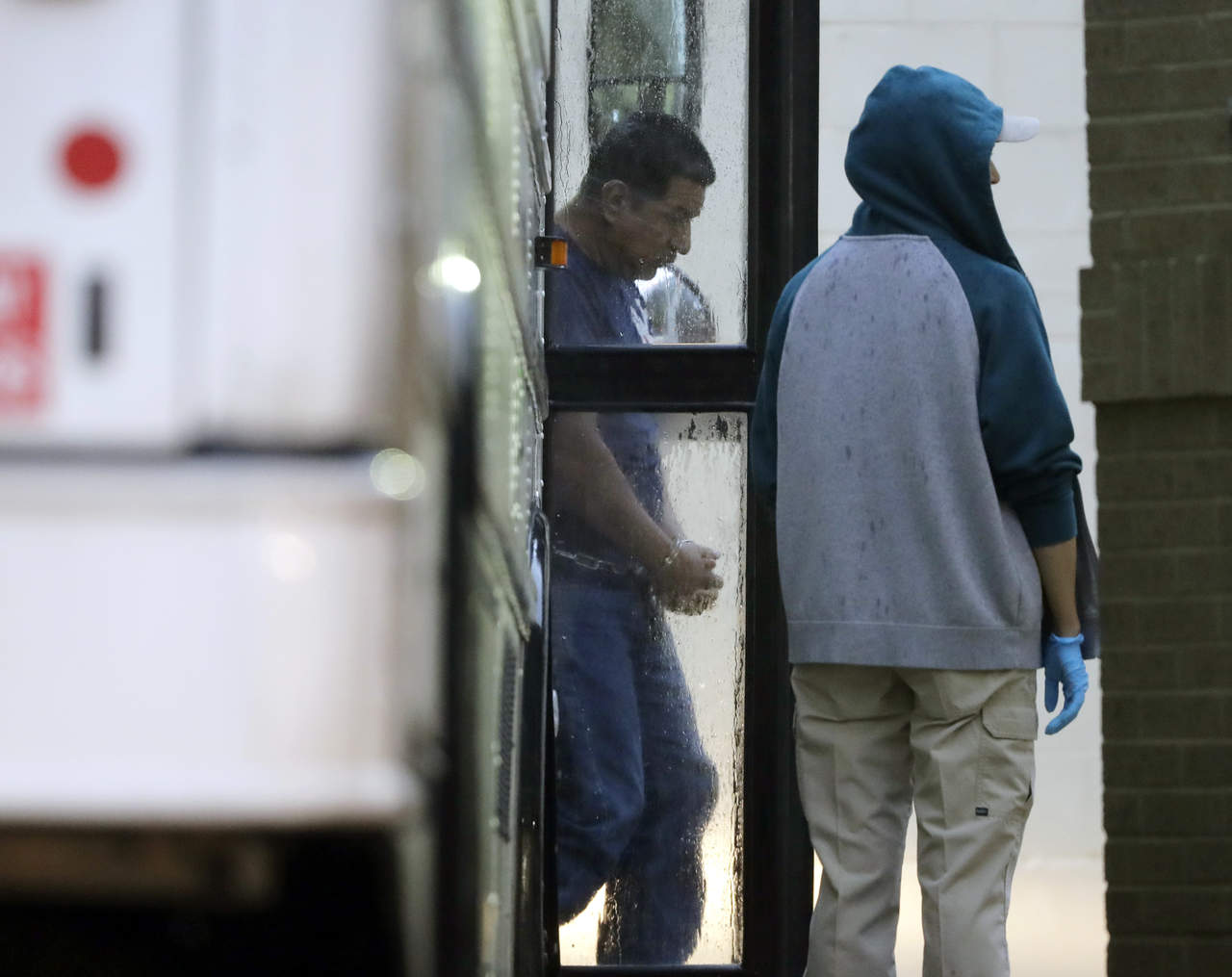 Un inmigrante llega con esposas y cadenas en los tobillos a la Corte Federal para su defensa. (AP)