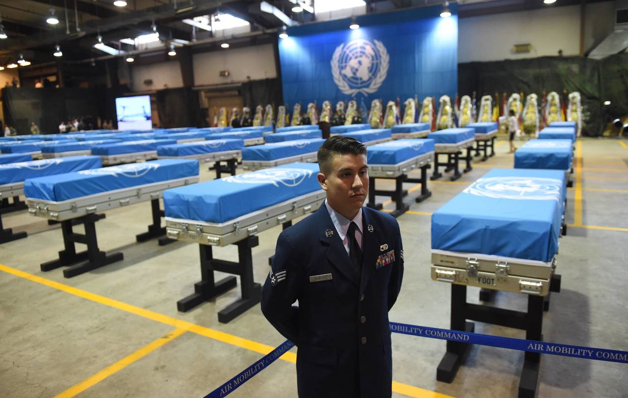 Guardia. Un aviador estadounidense permanece en guardia junto a los ataúdes que contienen los restos de soldados de EU. (EFE)